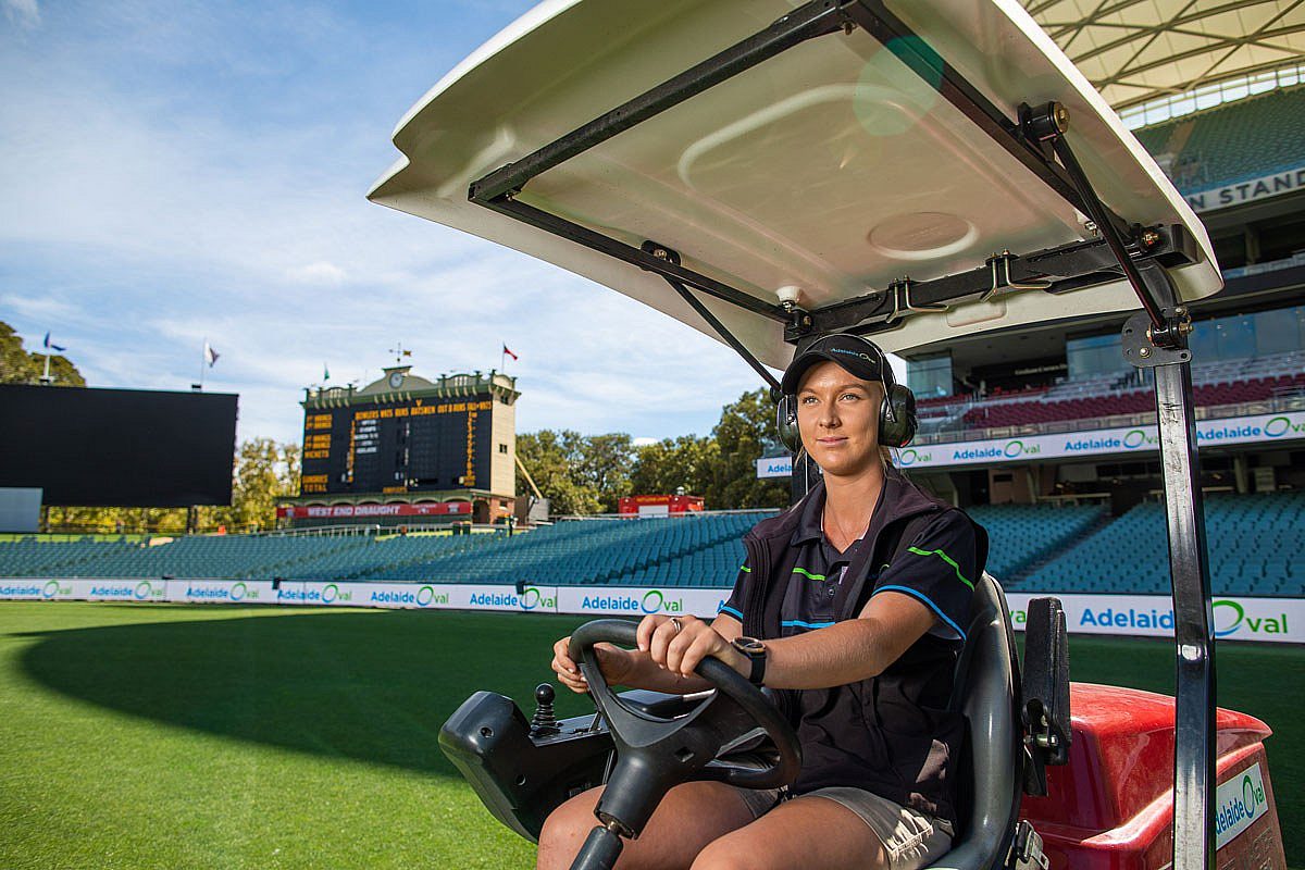 Female landscaping apprentice driving a ride on lawn mowing car at Adelaide Oval